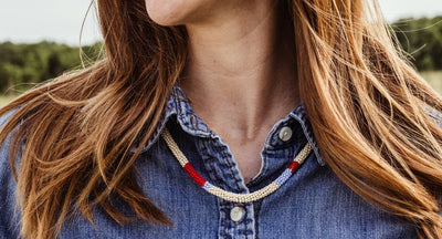 Women wearing blue bone bead necklace and black tank top