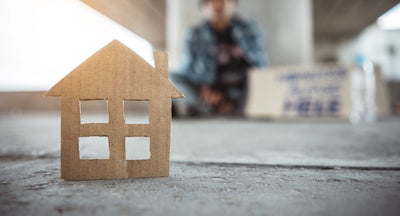 Cardboard cut out of a house standing on the ground