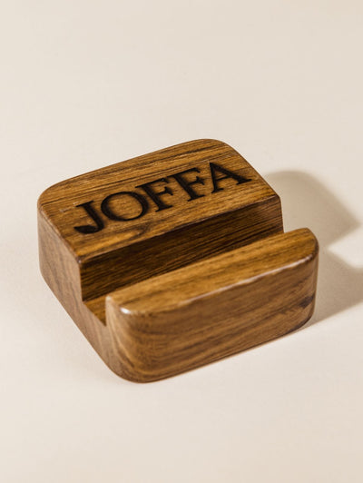 Closeup of wood cell phone stand with logo. 