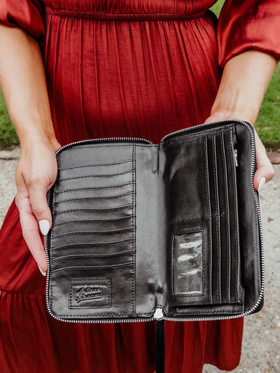 Model wearing a red dress is holding open an unzipped rani wallet