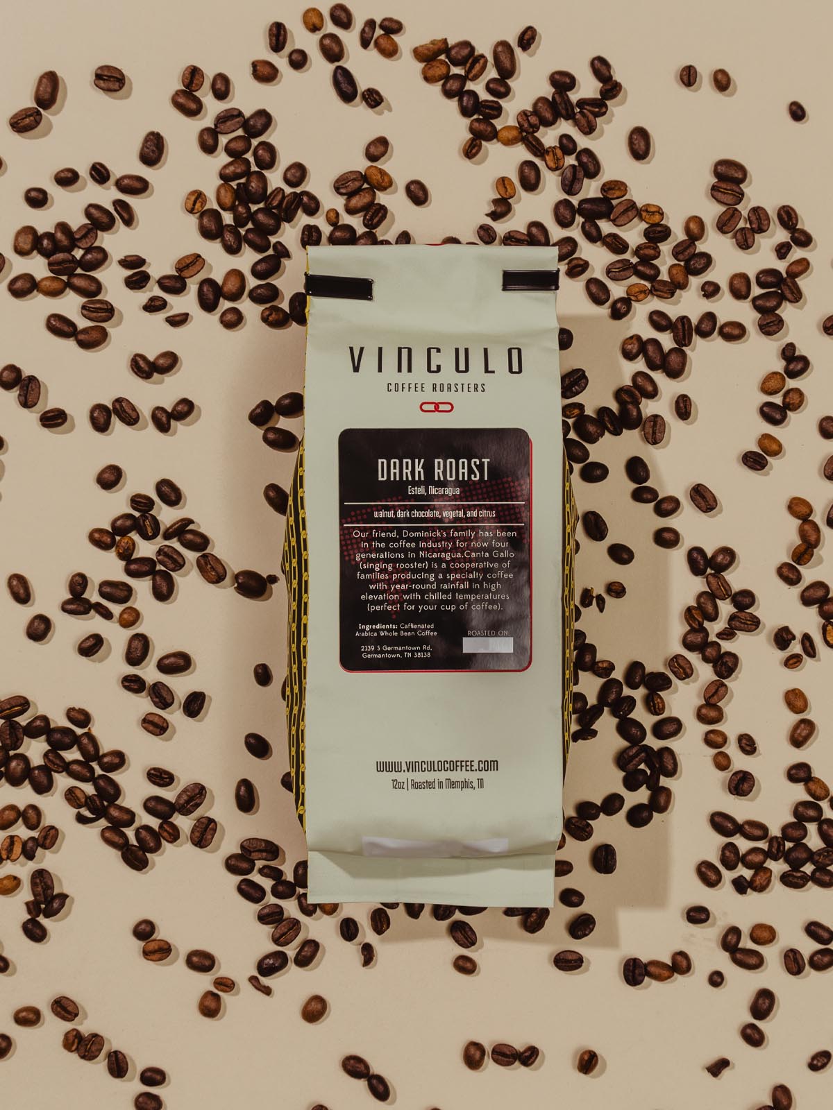 Bag of coffee beans laying on a table with coffee beans laid out on the table