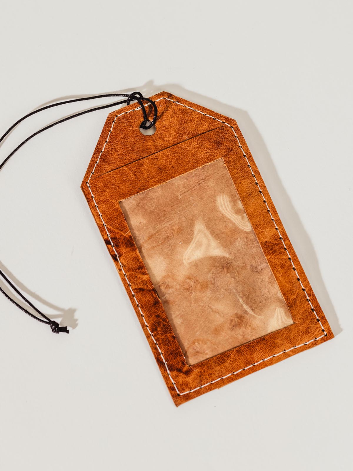 Frontside of leather luggage tag on white background.