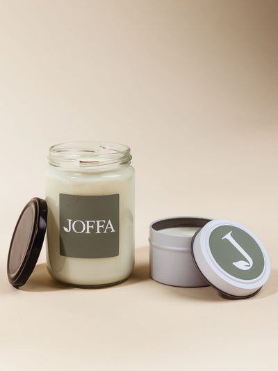 Customizable candles with logo stickers on cream background. 