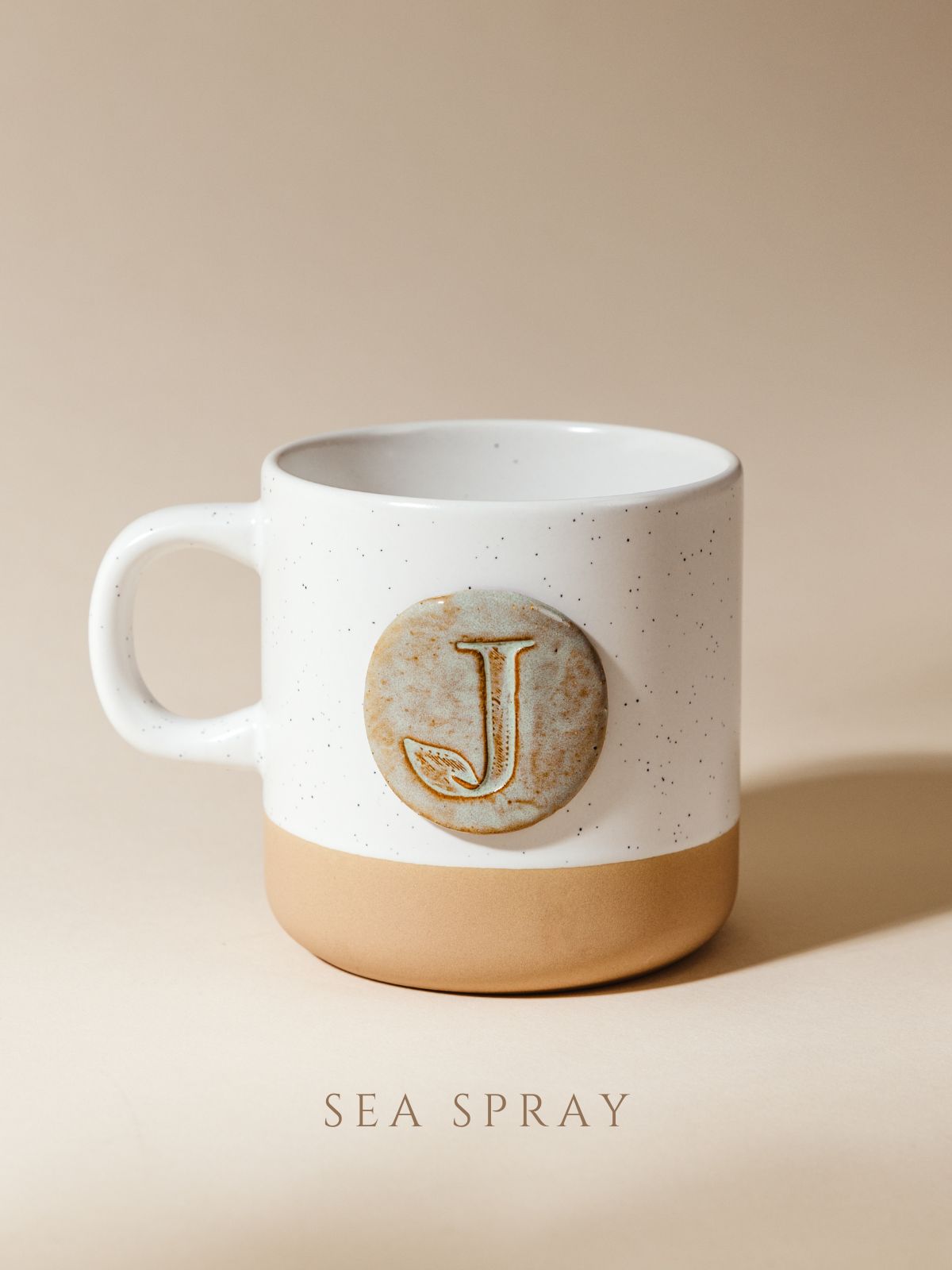 10 oz mug on cream background with sea spray glazed logo.