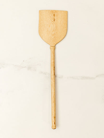 Wooden spatula on white granite counter top.