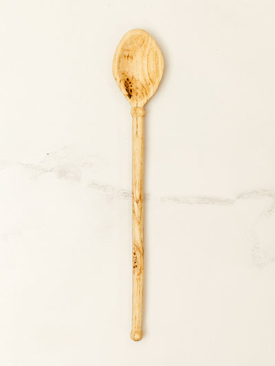 Wooden spoon on white granite counter top.