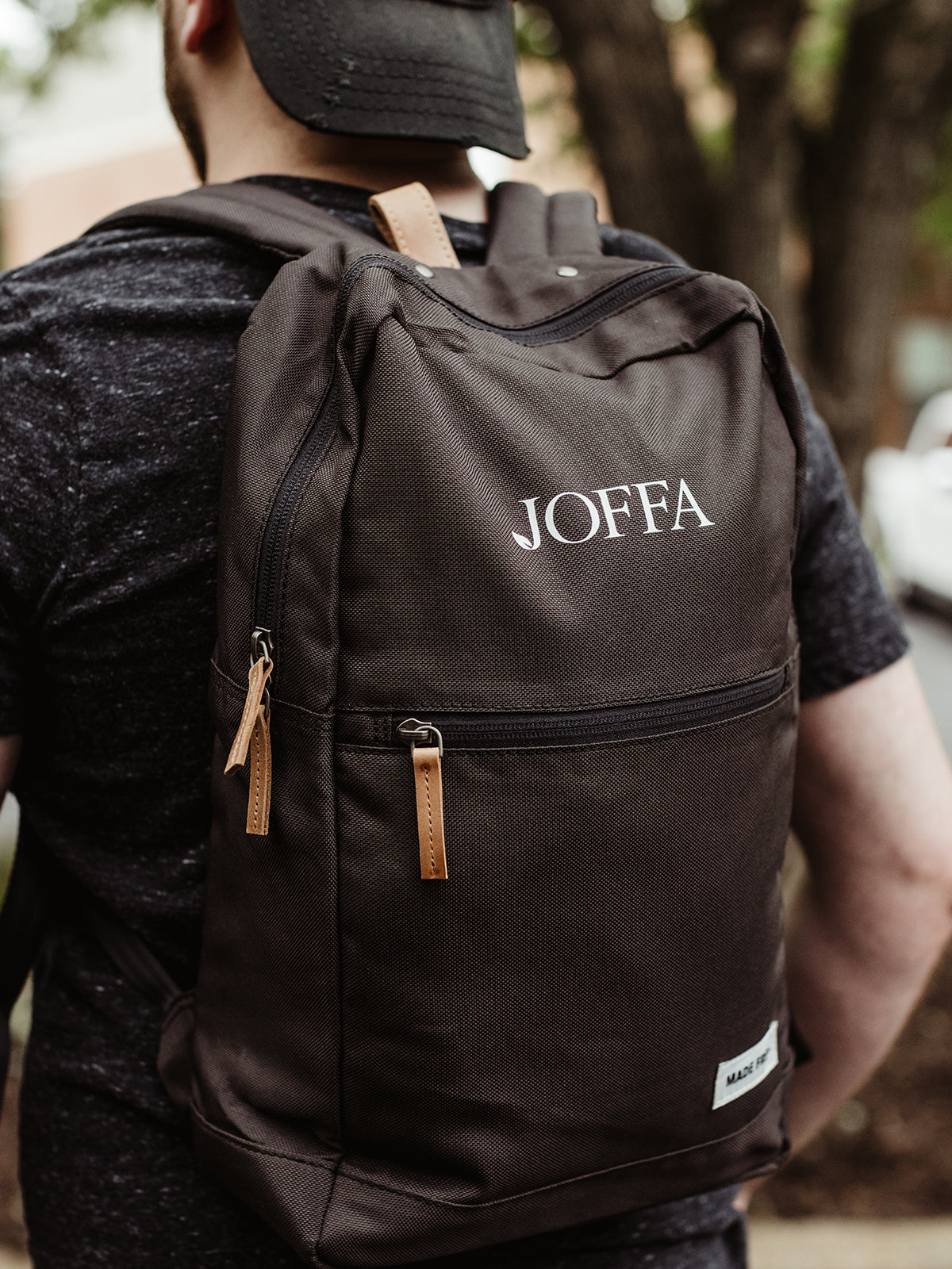 Male model wearing black screen printed backpack.