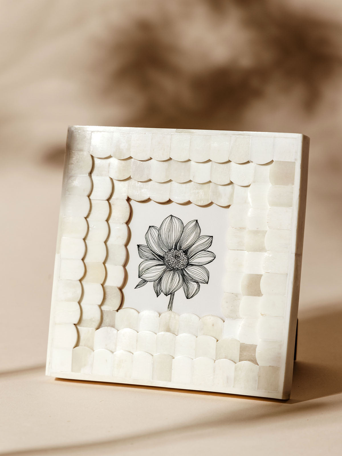 Square white scalloped frame made from bone, showcasing a detailed black and white floral illustration, displayed on a neutral background with soft shadows.