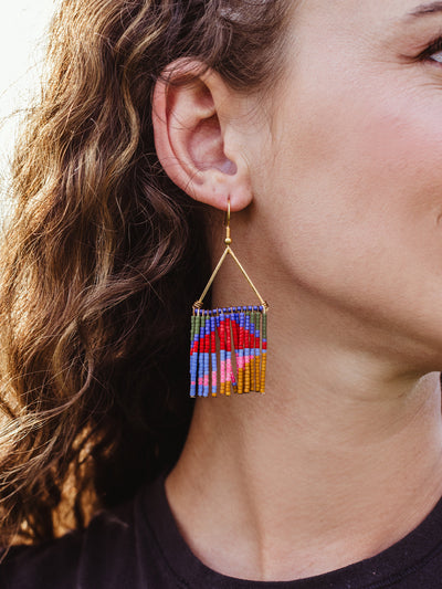 Female model wearing neon fringe earring with triangle top. 