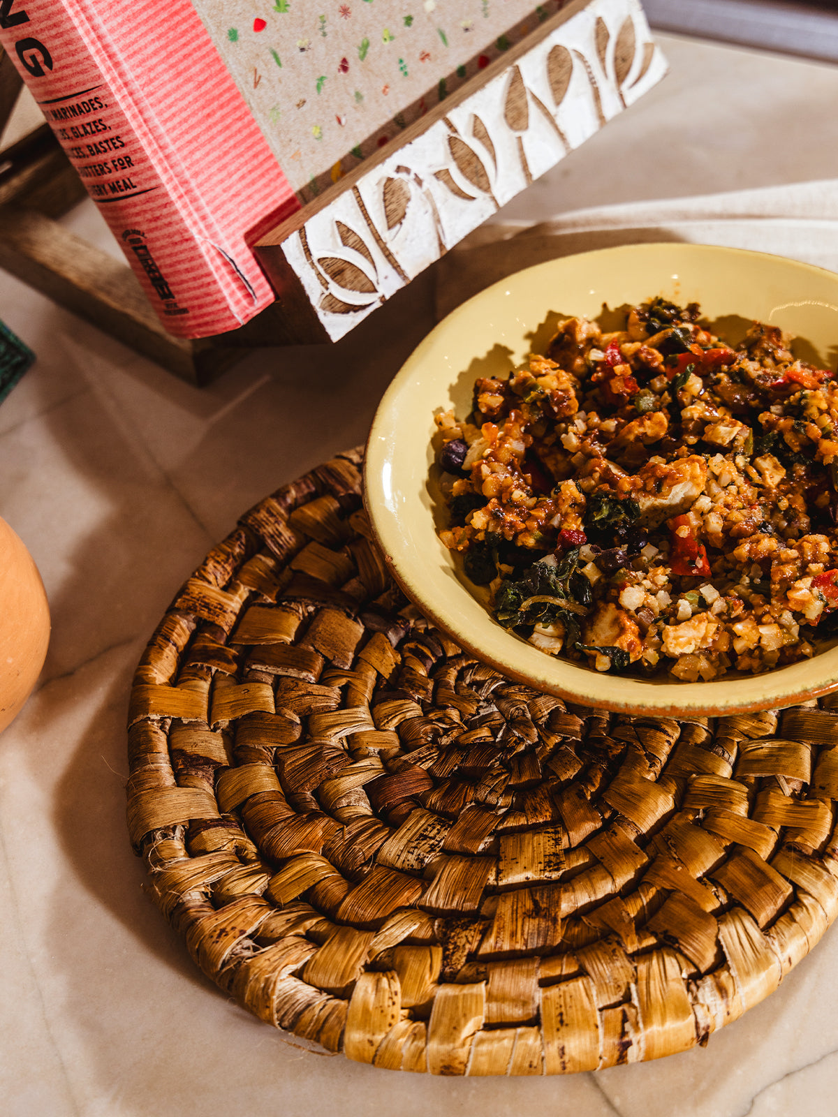 Banana leaf trivet with bowl of rice on counter.