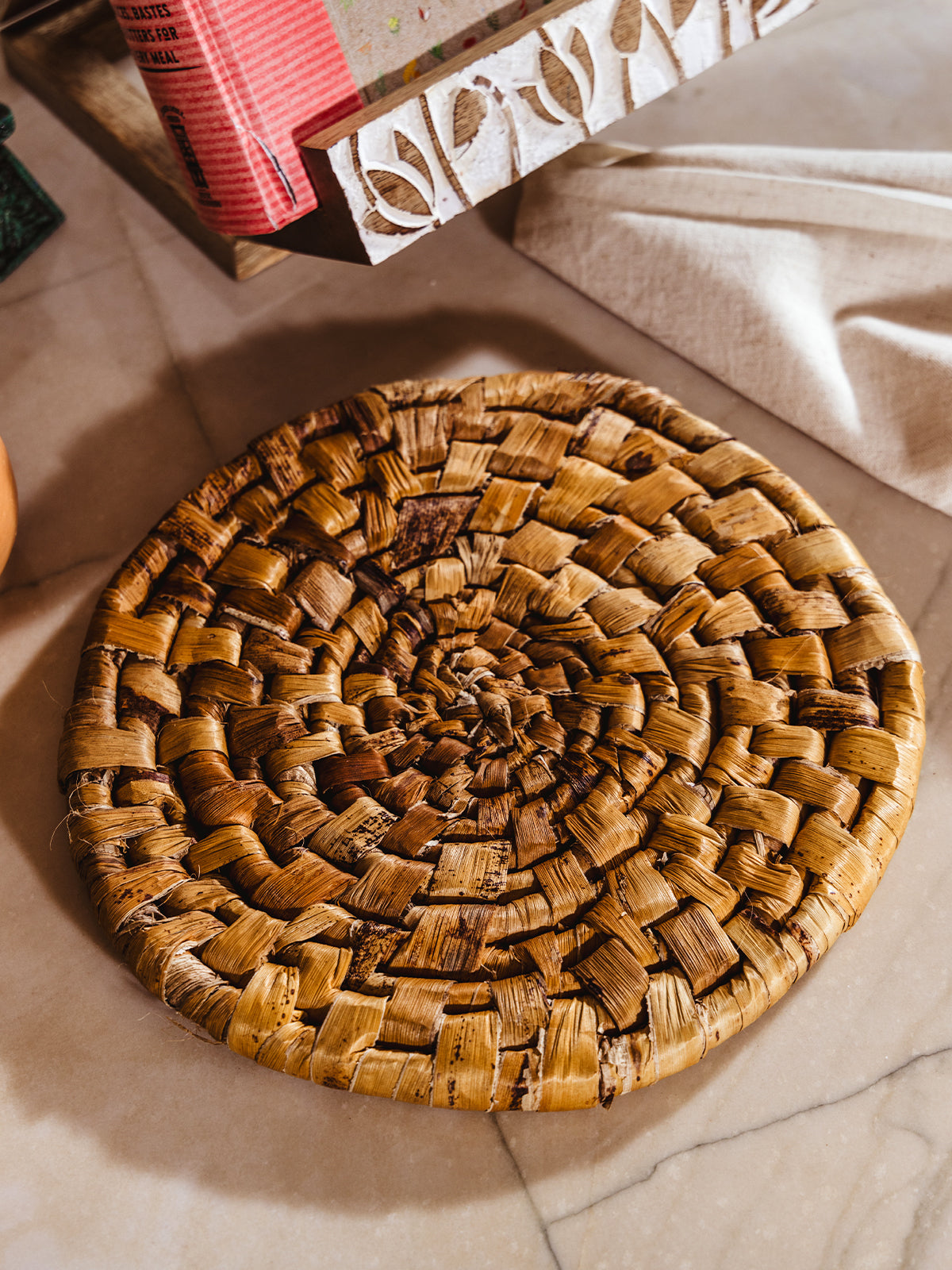 Banana leaf trivet on white counter.