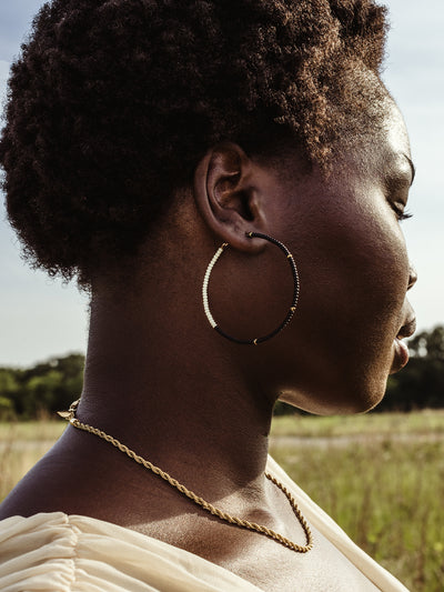 African female wearing Cafe Hoop earrings in outdoor setting. Image is closeup for details of earrings. 