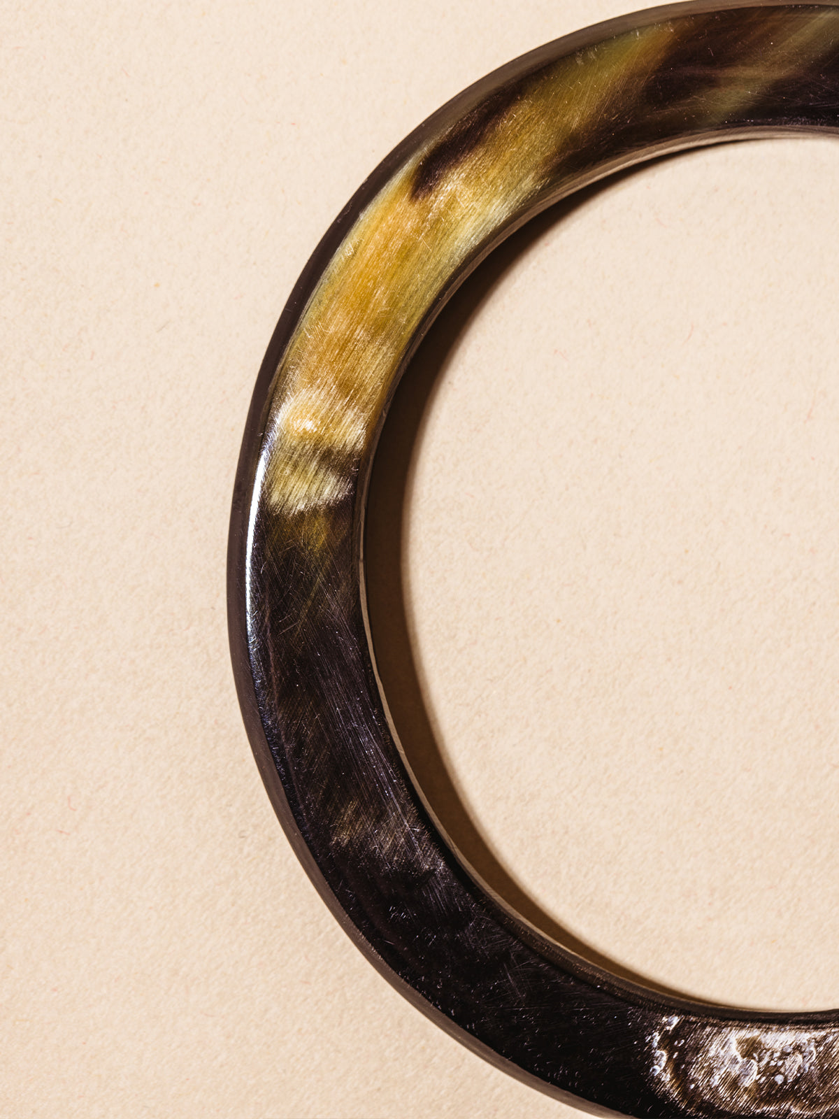 Close up of horn bangle on cream background 