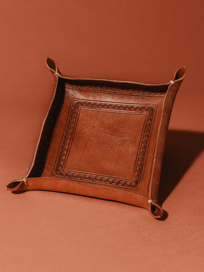 Leather stamped valet tray on tuscan orange background. 
