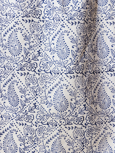 Close-up of a blue paisley and floral pattern on a handcrafted tea towel. Features intricate detailing and high-quality textile craftsmanship, ideal for sustainable home decor.