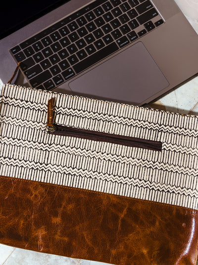 Close-up of a handcrafted laptop sleeve with a geometric pattern and brown leather base, highlighting the back zipper pocket for extra storage. Ideal for secure and stylish laptop protection.