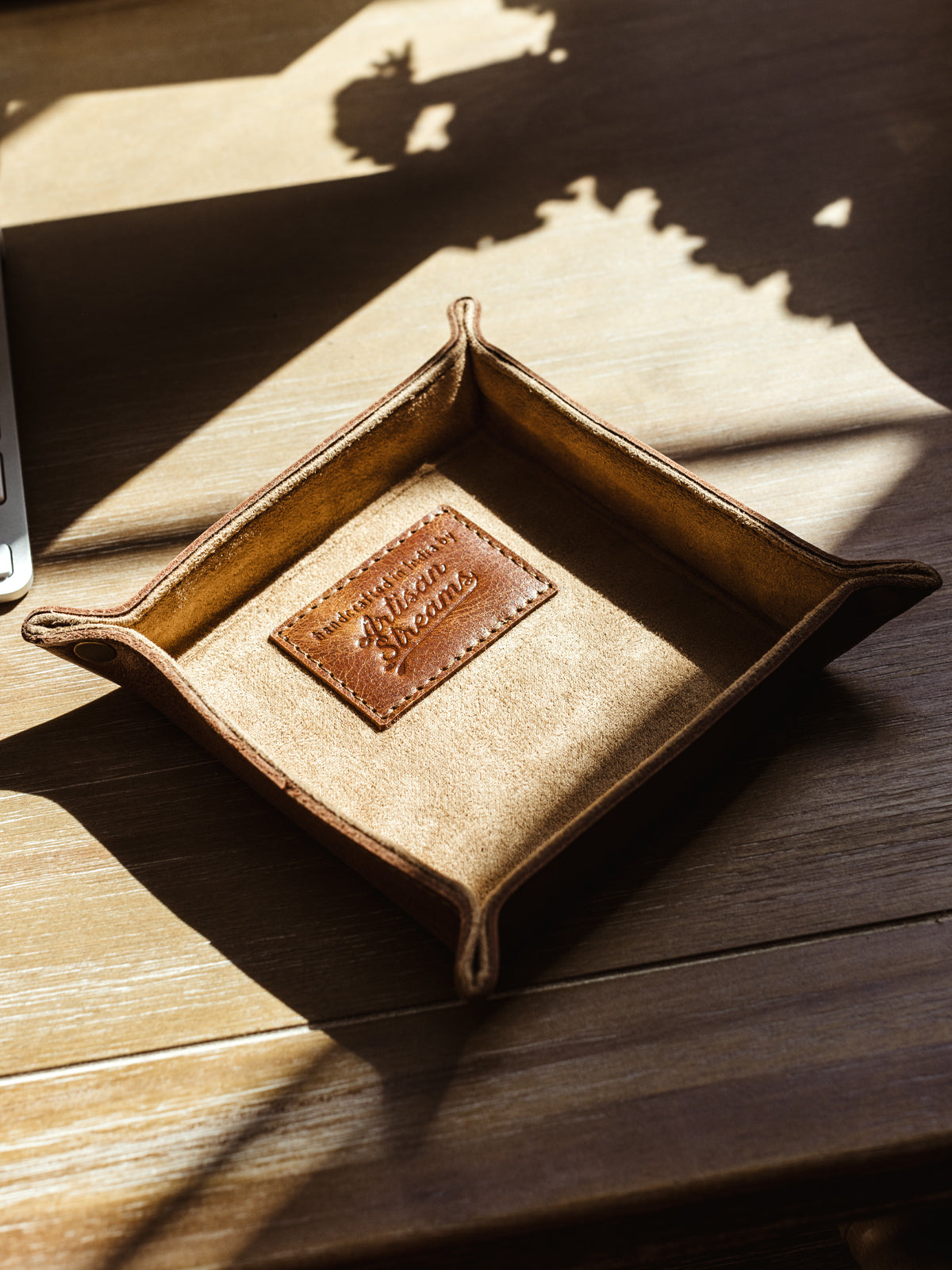 Small leather valet tray on wooden table.