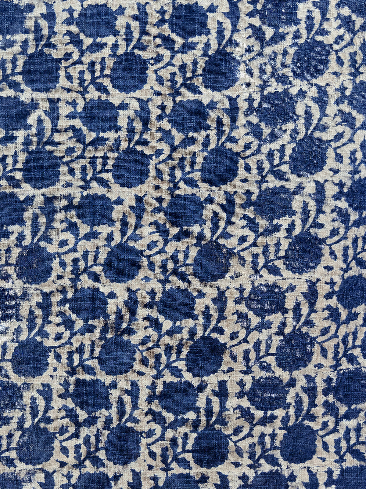 Close-up of a handcrafted blue and cream woven textile with a floral block print design. The intricate pattern showcases traditional craftsmanship, ideal for home decor or cozy throws.