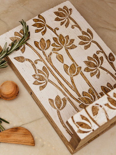 Lotus cookbook holder with lotus floral design laying flat on counter with green around the edges. 