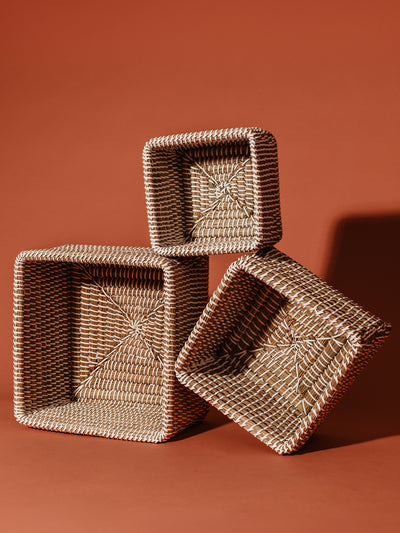 Large, medium, and small paisa cubes stacked together on a rustic orange background. 