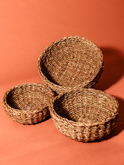 Seagrass basket set on rustic orange studio backdrop.