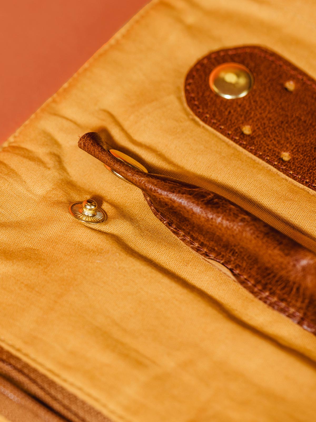 Close view of leather organizers for rings and earrings showing they snap in and out to take away for storage of other items. 