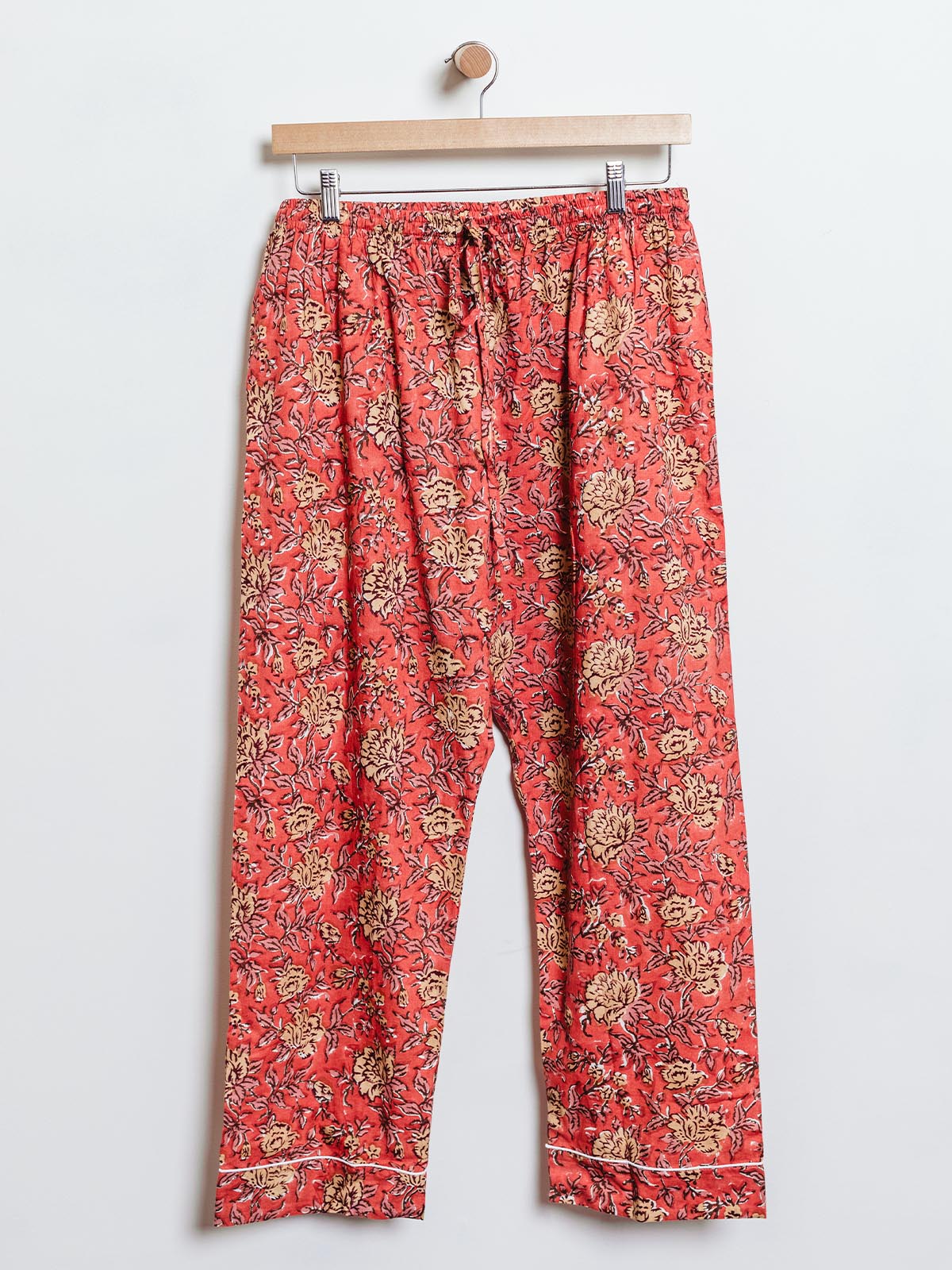 Ethically made lounge pants in vibrant red with a yellow floral pattern, designed with an elastic waistband and drawstring. These soft, handcrafted pants are perfect for casual wear or lounging, supporting sustainable fashion.