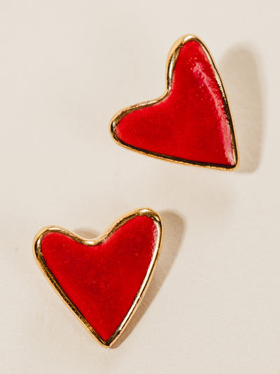 Red heart clay stud earrings with gold outline. Photographed on cream background.