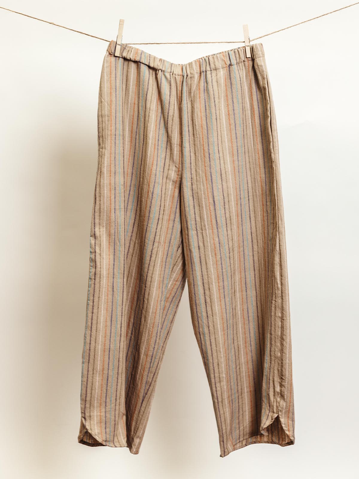 Ethically made brown lounge pants with multicolored vertical stripes, featuring an elastic waistband and relaxed wide-leg fit. These comfortable pants are perfect for cozy lounging or casual wear, handcrafted with care for sustainable fashion.