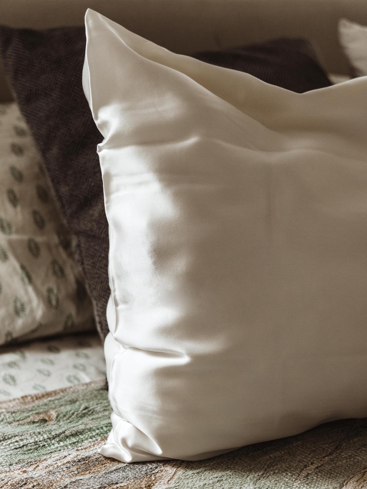 Luxurious white silk pillowcase on a bed, adding a touch of elegance and comfort to the bedroom decor.