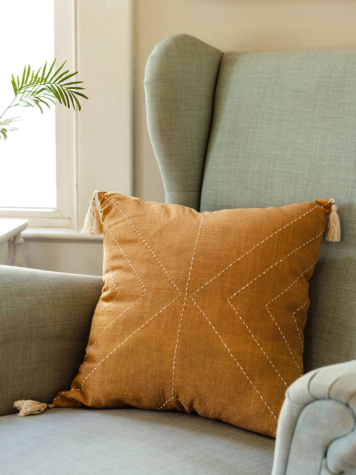 Mustard yellow pillow cover on light blue chair. 