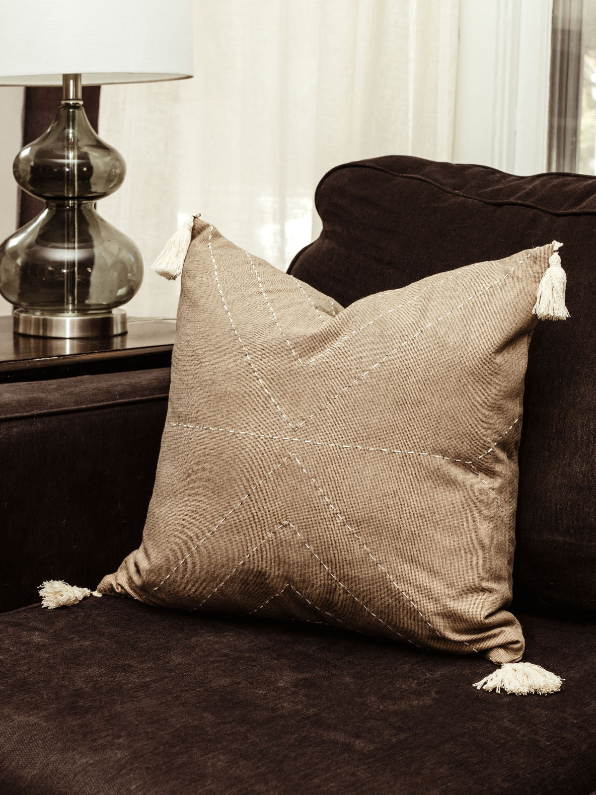 Charcoal pillow cover on dark black couch in living room. 