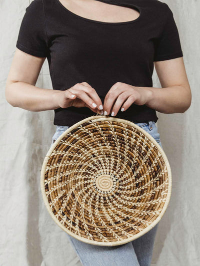 Model holding large brown and tan basket.